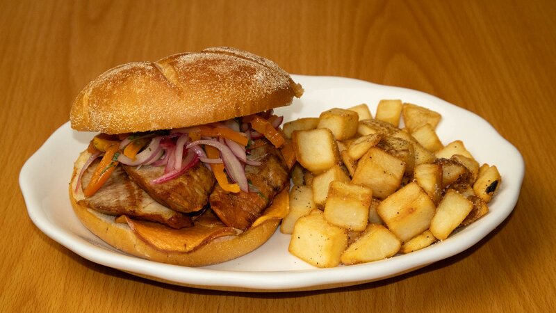 Chicken sandwich with side of potatoes